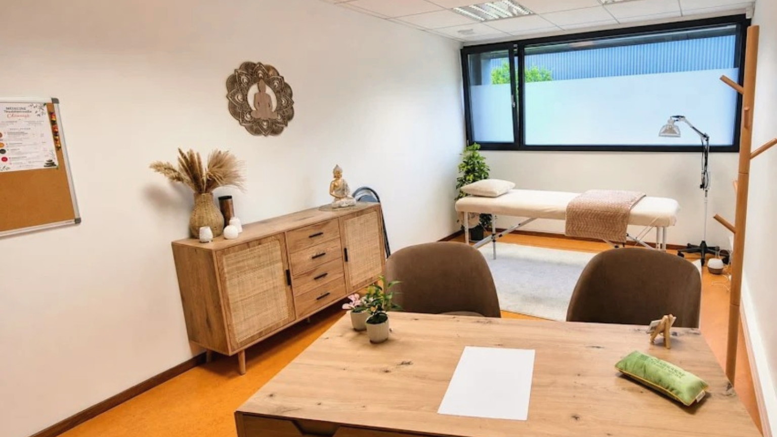 La salle de soin du cabinet : table de soin, bois clair et lumière naturelle